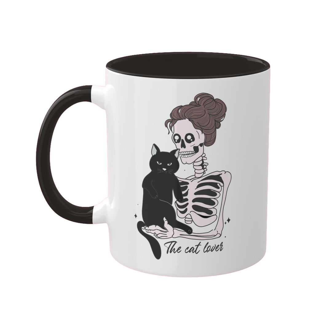 a black and white coffee mug with a skeleton holding a black cat