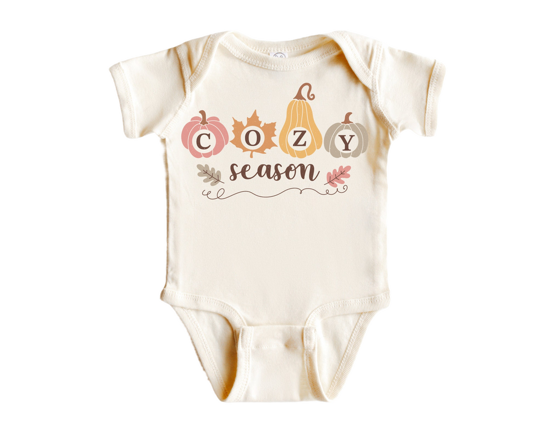 a white baby bodysuit with the words cozy season printed on it