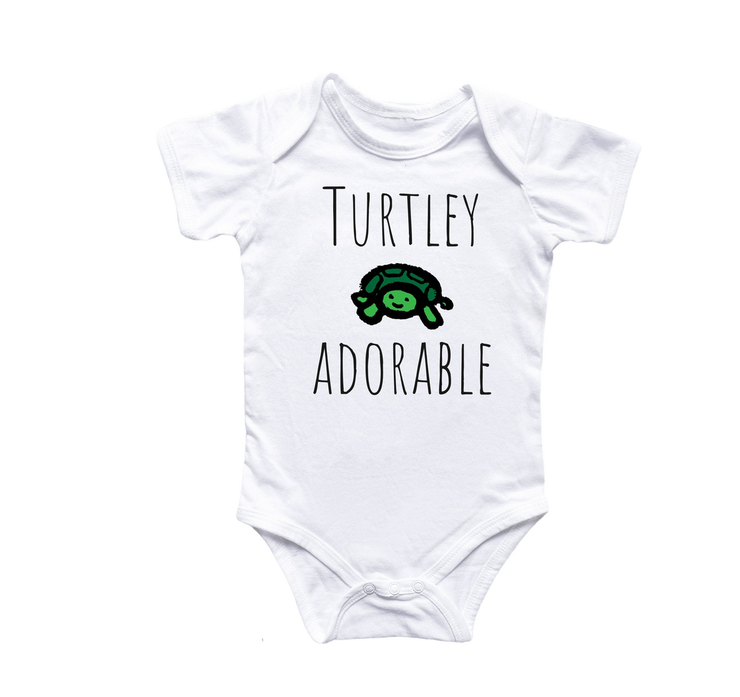 a white bodysuit with a turtley adorable on it