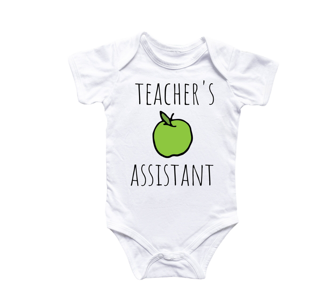 a white bodysuit with a green apple that says teacher's assistant