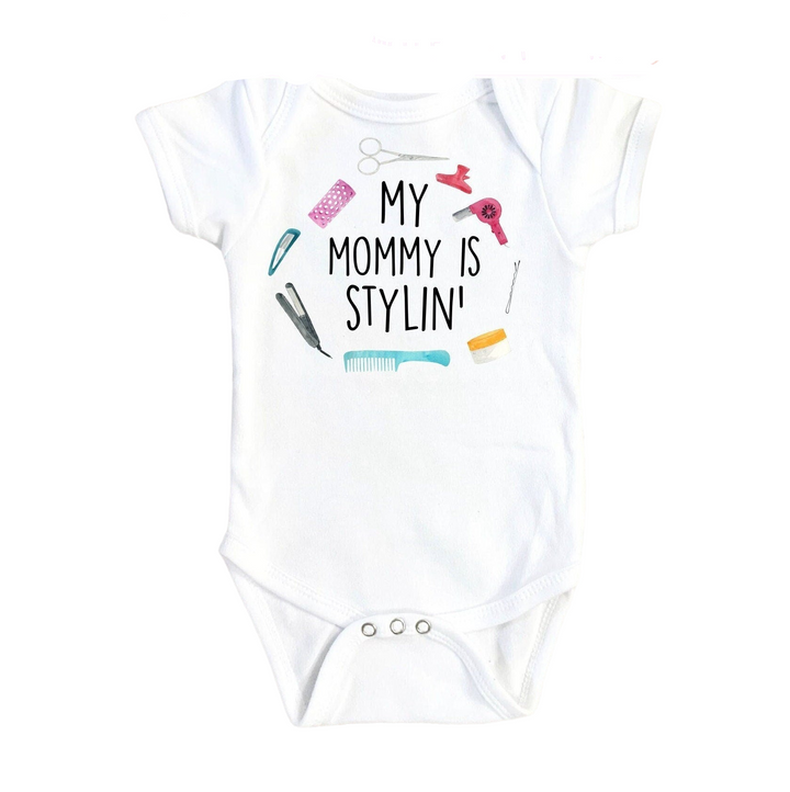 a white baby bodysuit with a picture of a hairdryer and combs