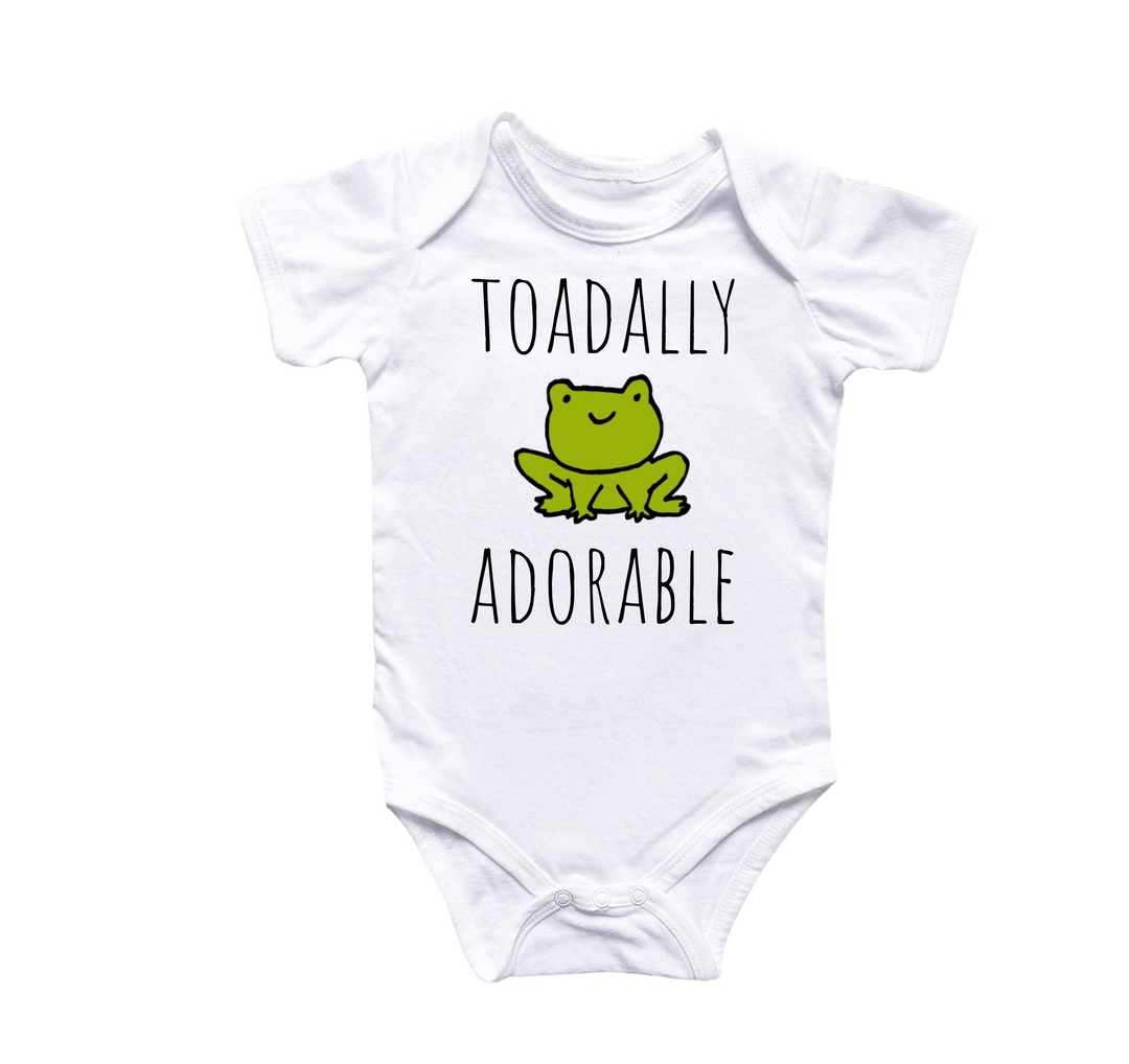 a white bodysuit with a frog saying toadally adorable