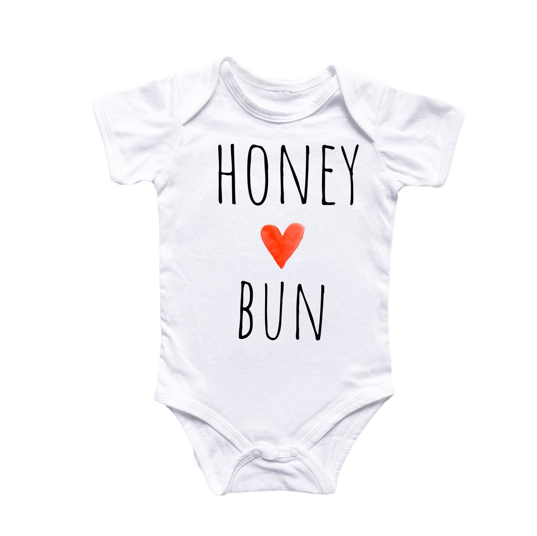 a white bodysuit with a red heart that says honey bunn