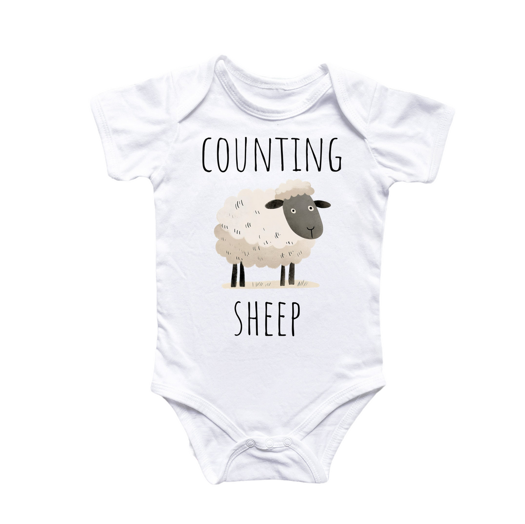 a white baby bodysuit with a sheep on it