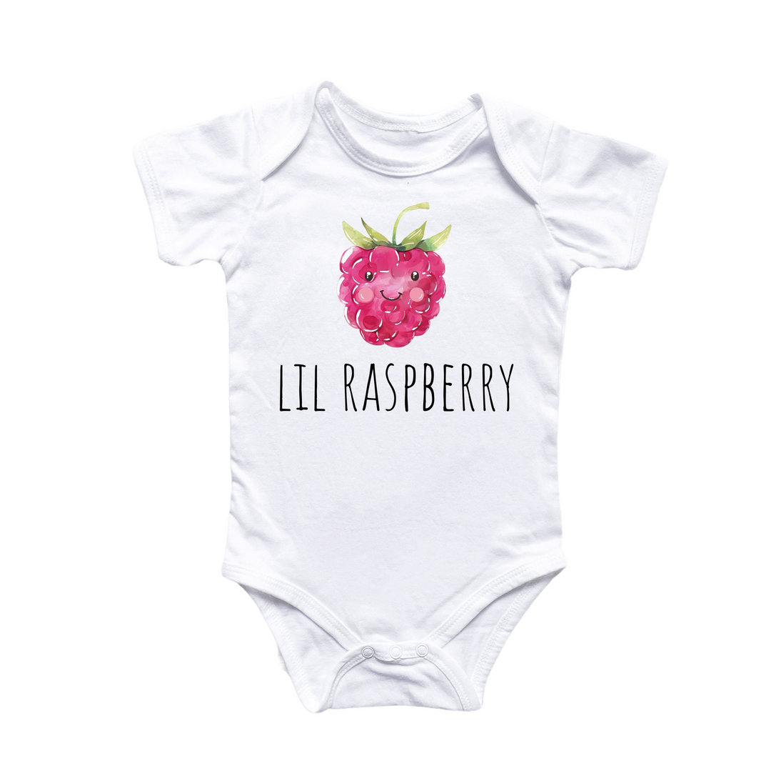 a white bodysuit with a raspberry on it