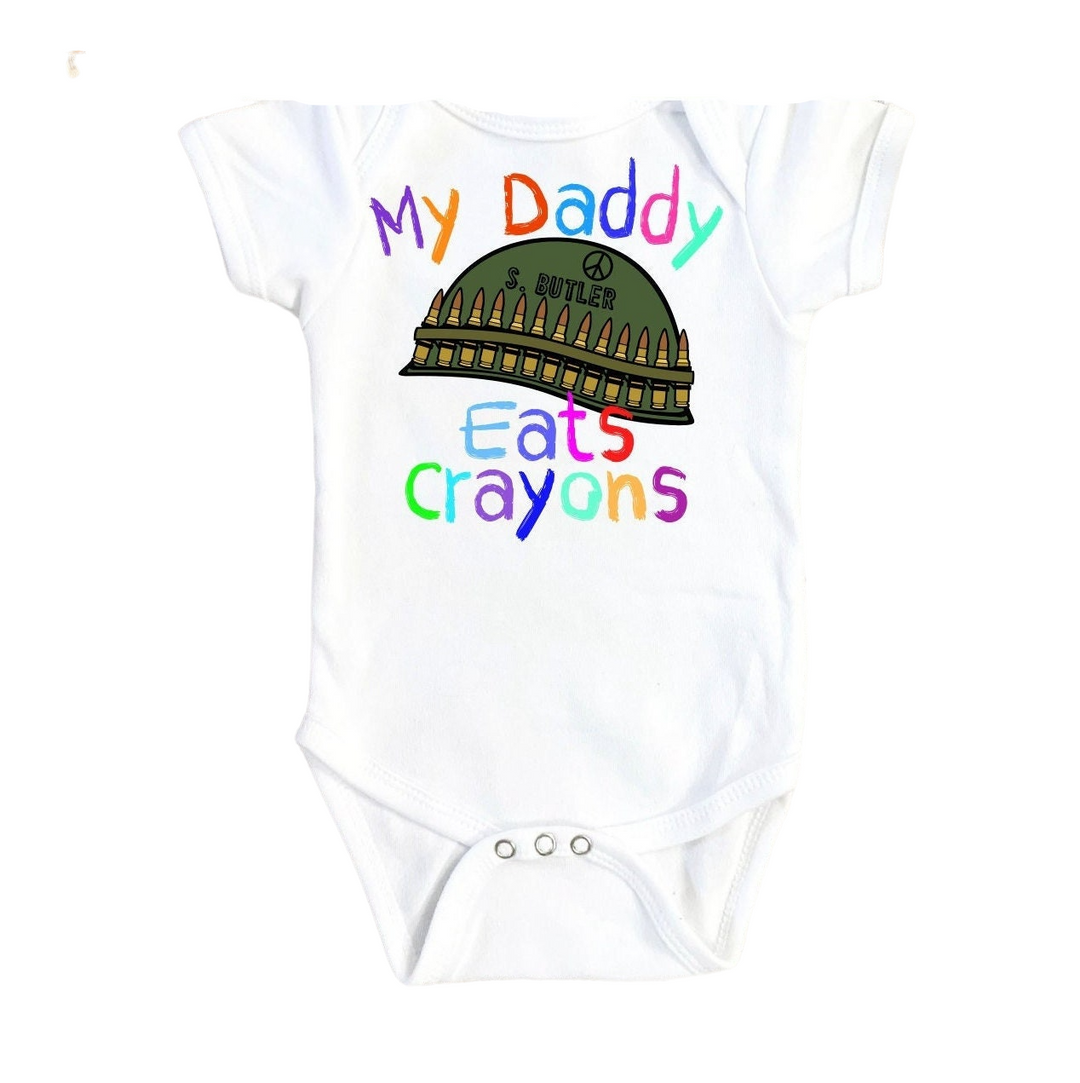 a white bodysuit with the words my daddy eats crayons on it