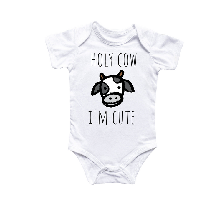 a white baby bodysuit with a black and white cow on it