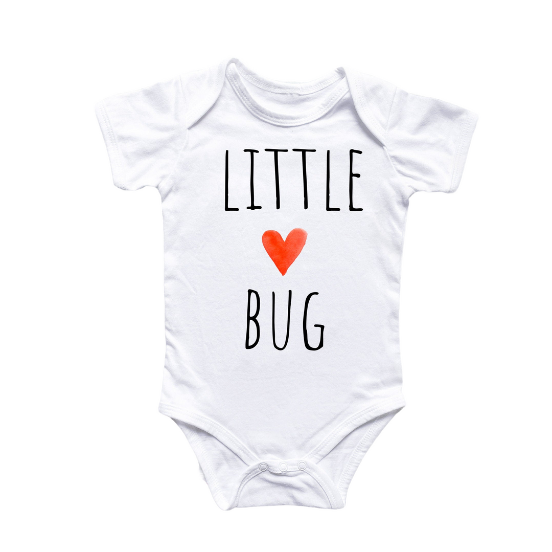 a white bodysuit with a red heart that says little bug