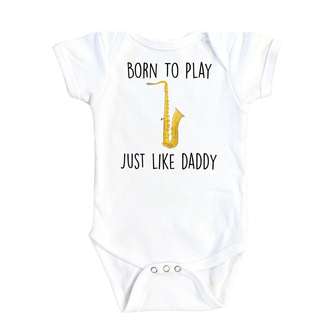 a white bodysuit with a yellow saxophone on it