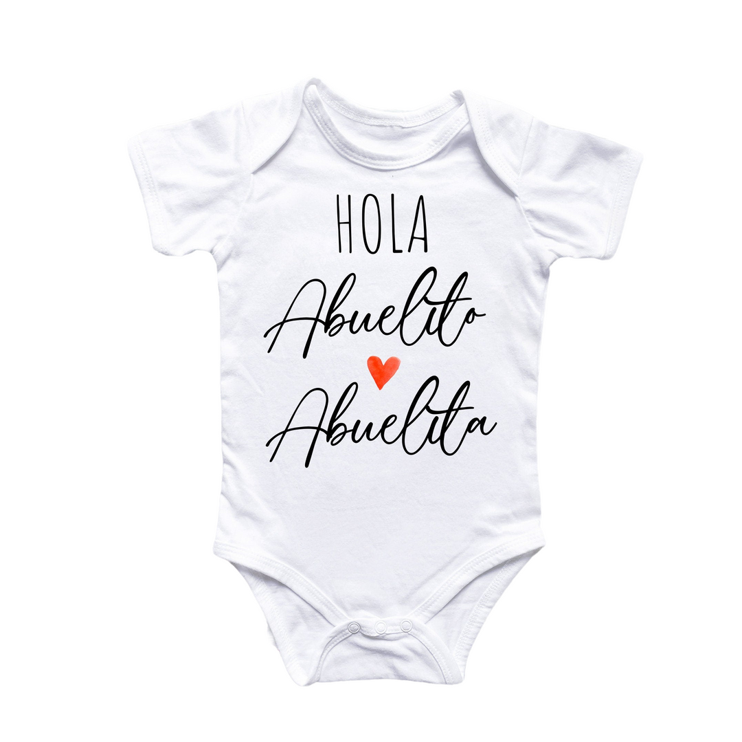 a white baby bodysuit with the words hola auello and an orange heart