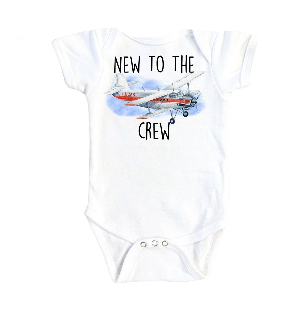 a white bodysuit with a picture of a plane on it