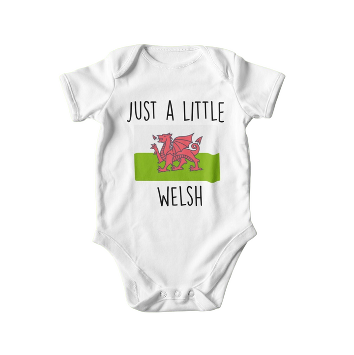 a white baby bodysuit with the words just a little welsh on it