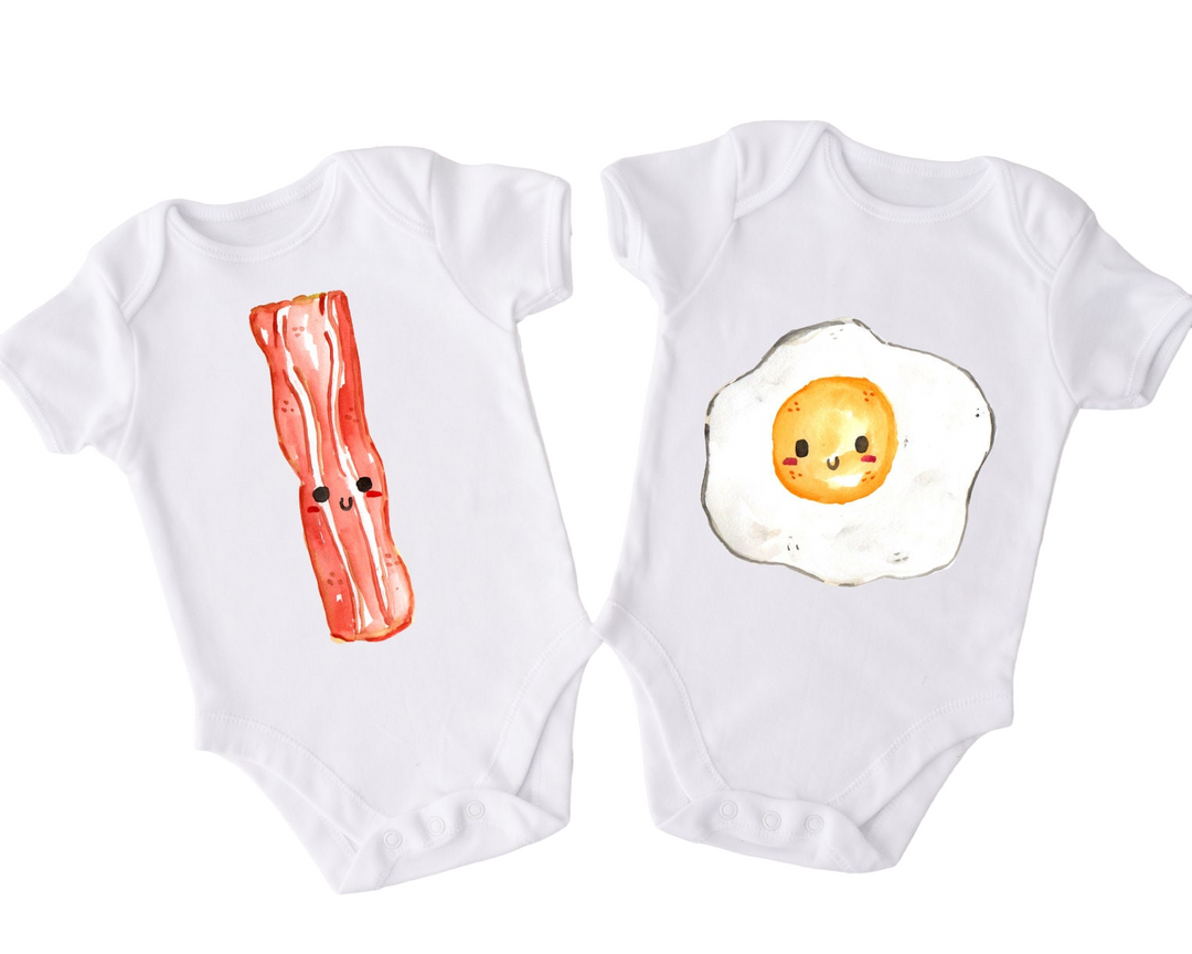 two baby onesuits with bacon and an egg on them