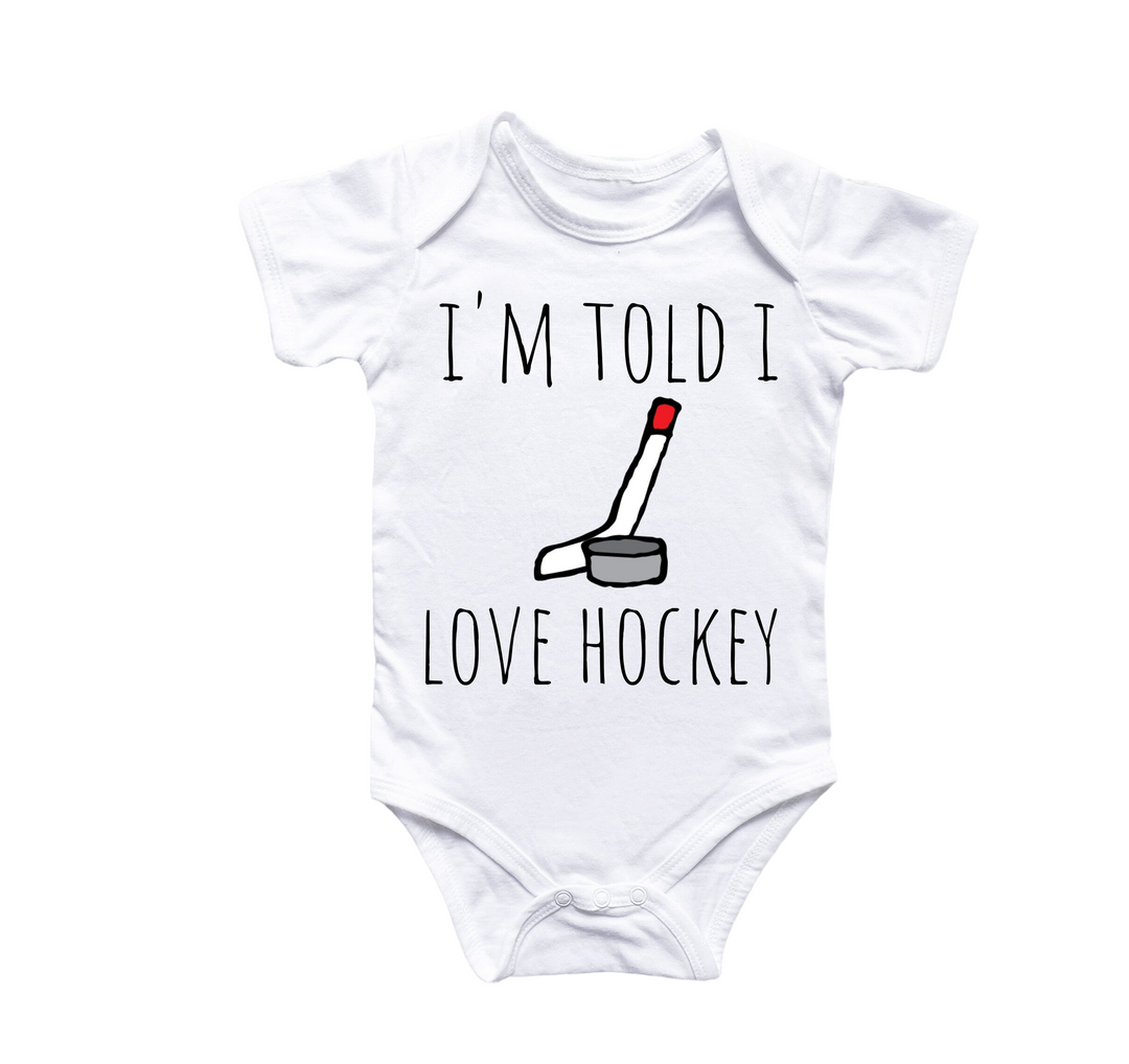 a baby bodysuit that says i'm told i love hockey