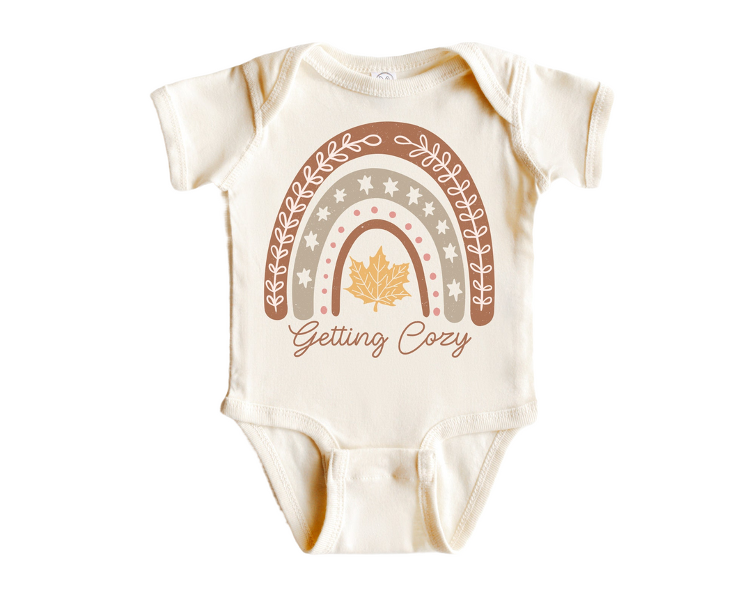 a baby bodysuit with a rainbow and the words getting cozy