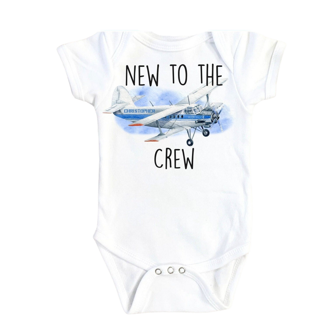 a white bodysuit with a picture of a plane on it